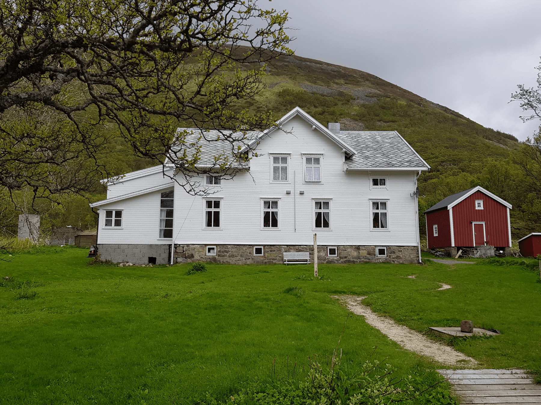 Det hvite hovedhuset på Øksnes Leirsted, sett fra hagen