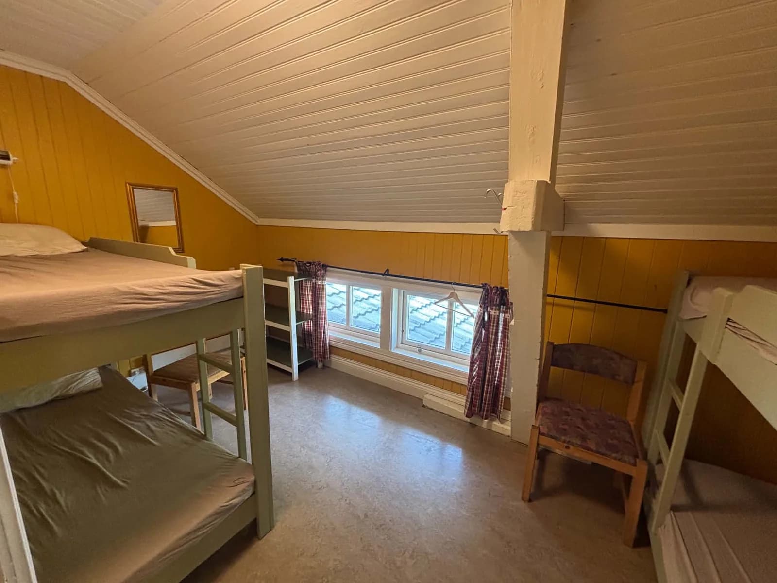 Loftsrom med køyesenger og gul aksentvegg