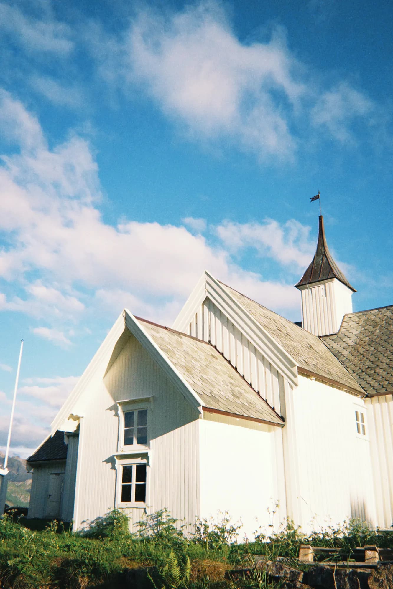 Øksnes kirke med fjell og blå himmel