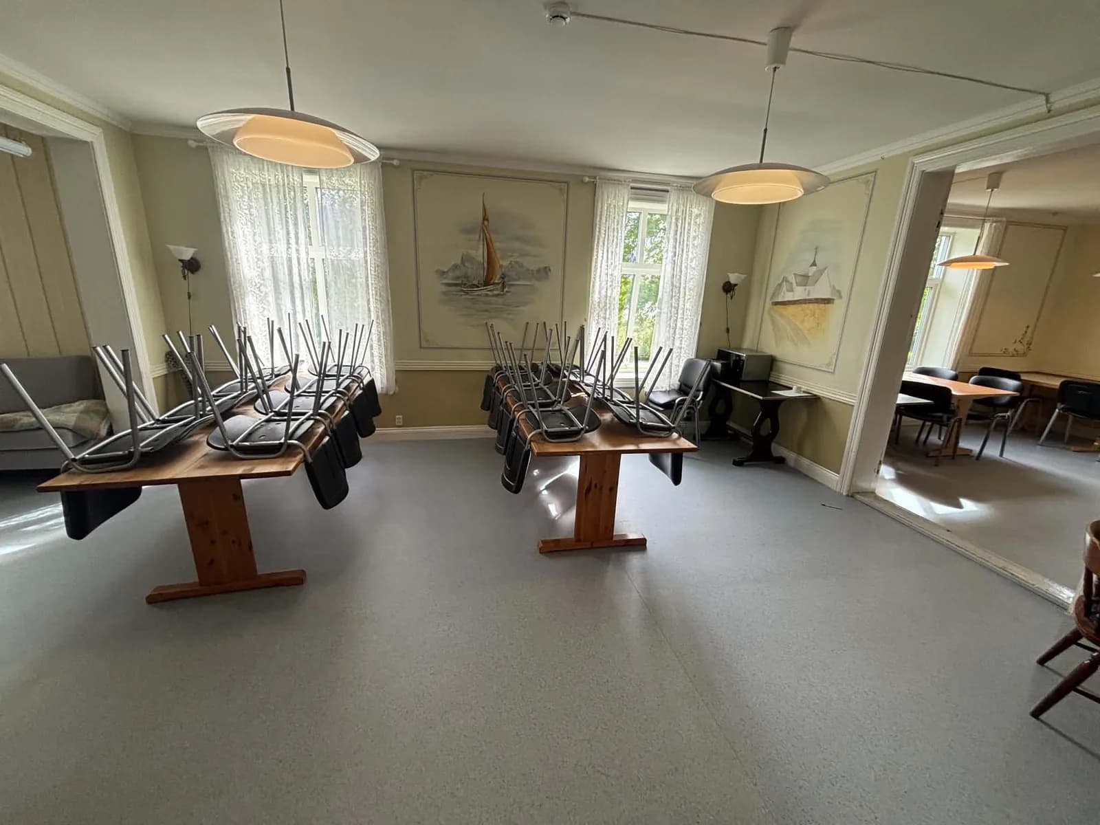 Stor spisesal med flere langbord og store vinduer